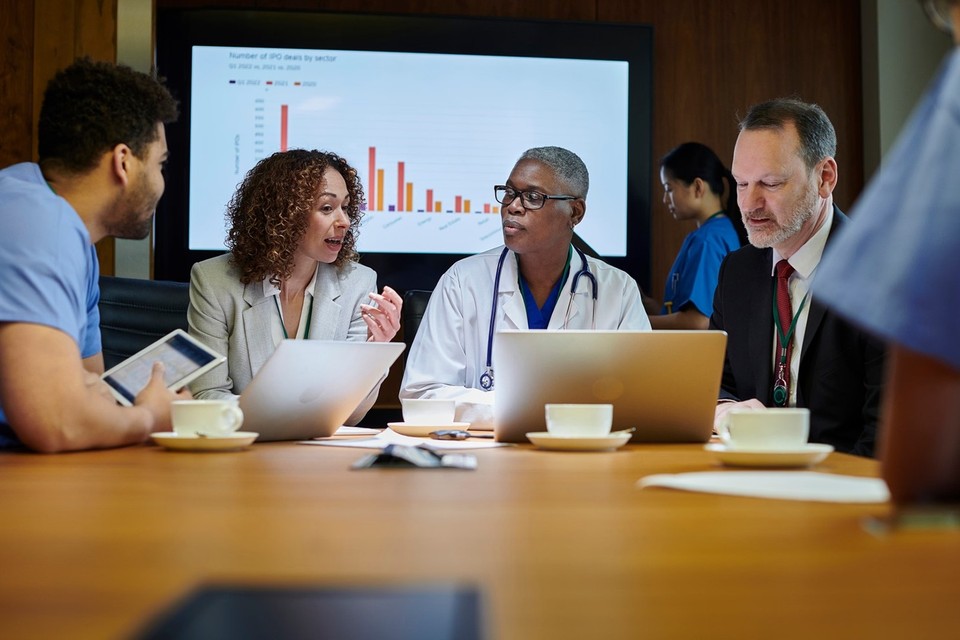 people meeting at a table with documents.